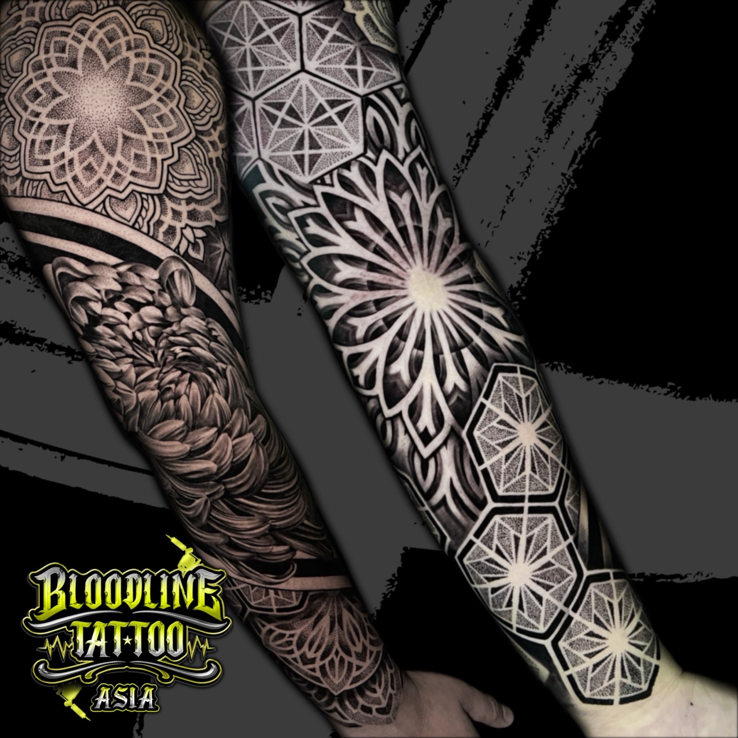 Full sleeve pairing hexagonal dotwork grids, sunburst mandalas, and a shaded chrysanthemum in ornamental black and grey, at Bloodline Tattoo Bali.