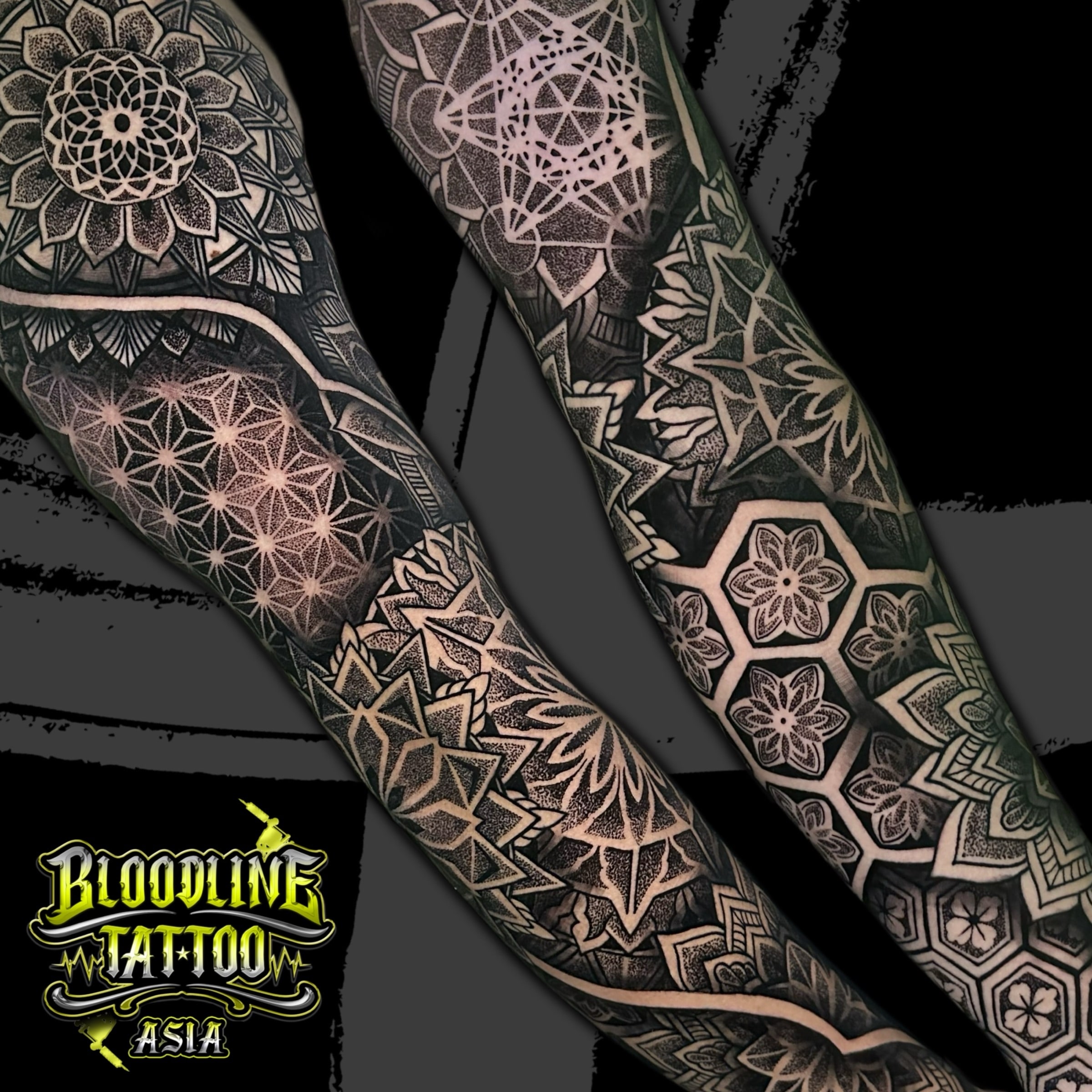 Dual-arm geometric sleeves with layered mandalas, Flower of Life grids, and hexagonal floral dotwork in high-contrast black and grey, at Bloodline Tattoo Bali.